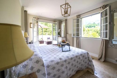 une chambre avec un lit et une grande fenêtre dans l'établissement Spacious villa in Tourrettes-sur-Loup with Private Lake access Sleep 16, à Tourrettes-sur-Loup