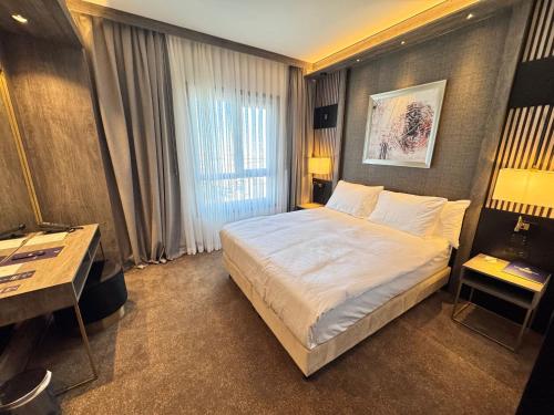 a hotel room with a bed and a desk at Doubletree By Hilton Kars Sarikamis in Sarıkamıs