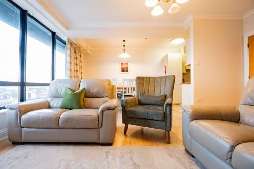 a living room with a couch and a chair at Dockside Penthouse - Free Parking in Galway