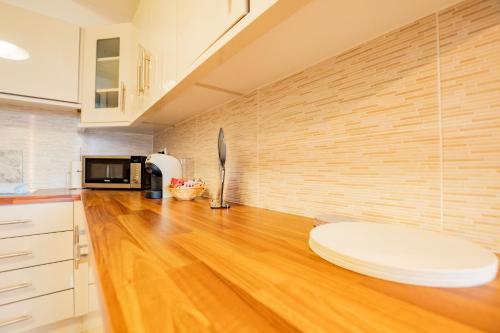 a kitchen with a wooden floor and a white table at Dockside Penthouse - Free Parking in Galway