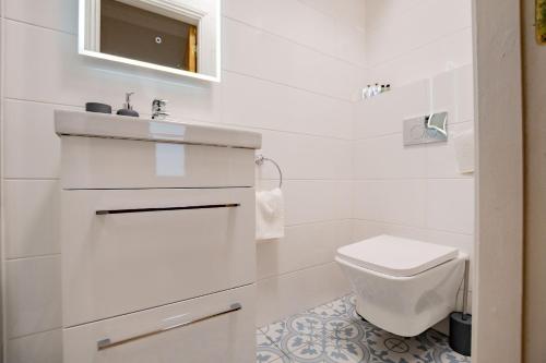 a white bathroom with a sink and a toilet at Dockside Penthouse - Free Parking in Galway