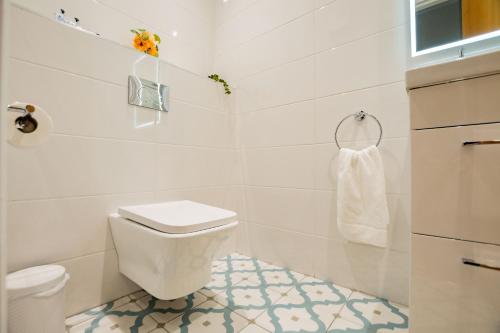 a white bathroom with a toilet and a sink at Dockside Penthouse - Free Parking in Galway