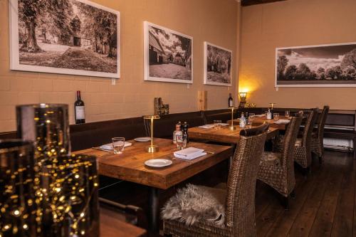 a restaurant with wooden tables and chairs and pictures on the wall at Hotel Villa Tripaldi in Schönberg in Holstein
