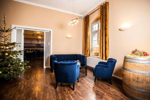 a living room with a christmas tree and blue chairs at Hotel Villa Tripaldi in Schönberg in Holstein