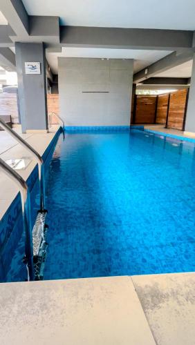 a large swimming pool with blue water in a building at Farath Smart Apartment in Lagos