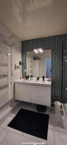 une salle de bain avec un lavabo blanc et un miroir dans l'établissement Unik vannes, à Vannes