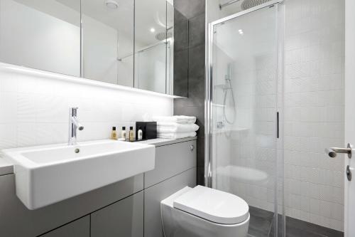 a bathroom with a sink and a toilet and a shower at Design-led serviced apartments, Camden in London