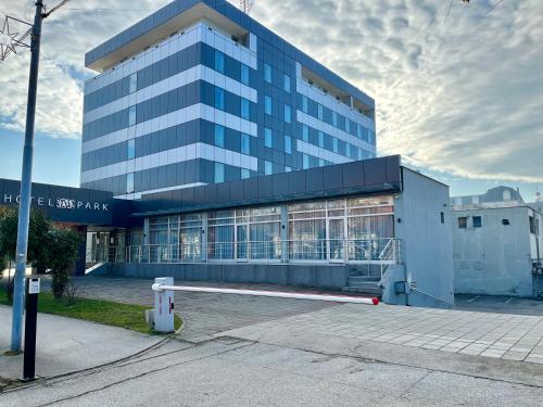 a large blue building with a building at Hotel Monogram Park in Ruma