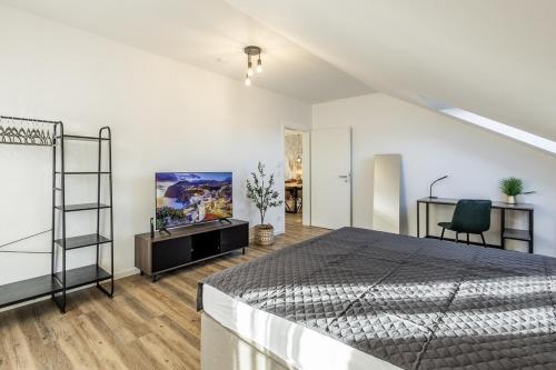 a bedroom with a bed and a desk and a tv at Sky Penthouse 08 I Aufzug I TV I Gasgrill I WiFi in Hamm