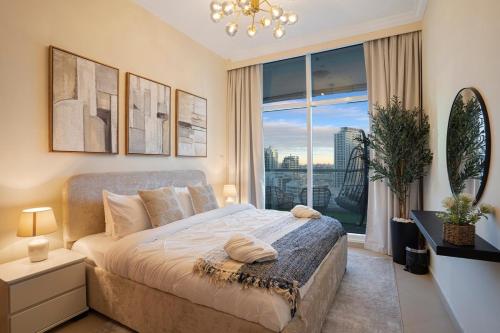 ドバイにある13 - Stylish Palm view Family Apartment in Dorra Bay - Beach Accessのベッドと大きな窓のある寝室