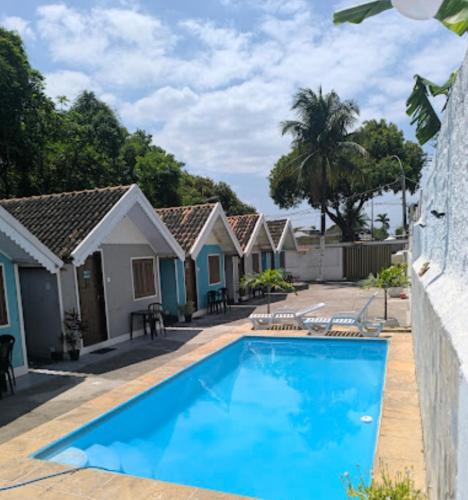 a swimming pool in front of a row of houses at Pousada do Sol in Pedra de Guaratiba