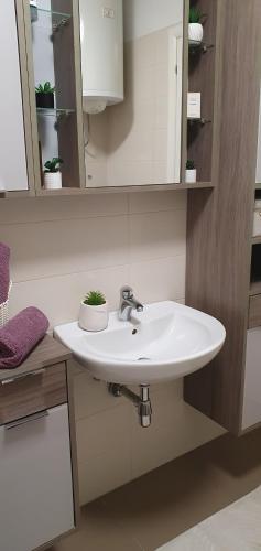 a bathroom with a white sink and a mirror at Apartment JASS next to MALL OF SPLIT in Split