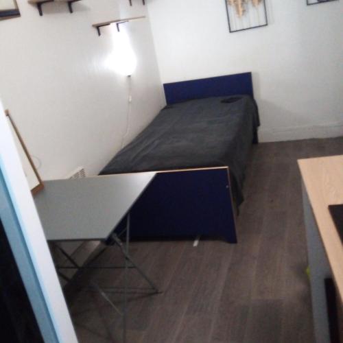 une petite chambre avec un lit et un bureau dans l'établissement Studio Centre de Paris en face de la Seine, à Paris