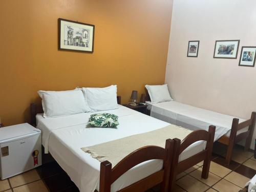 a bedroom with two beds with white pillows at Pousada das Missoes in São Miguel das Missões