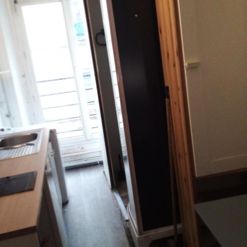 une cuisine avec une porte ouverte sur une fenêtre dans l'établissement Studio Centre de Paris en face de la Seine, à Paris