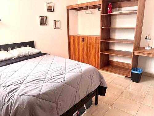 a bedroom with a bed and a book shelf at A Estrenar Alberca Vista al Río y Mar con AC in Conchal