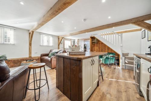 an open kitchen and living room with a staircase at Countryside Barn with Hot Tub in New Forest in Hordle