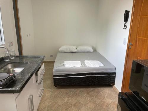 a small room with a bed and a sink at Condomínio Residencial Vitória 3 in Sao Paulo
