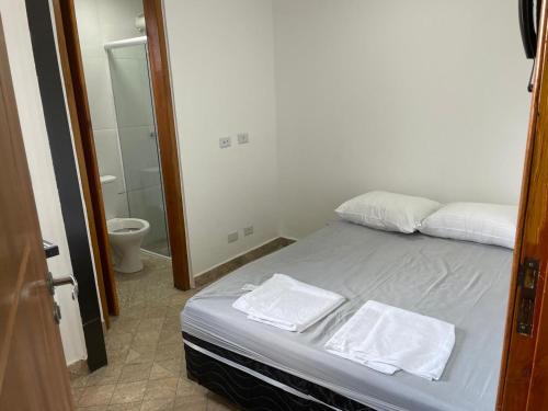 a bedroom with a bed with two towels on it at Condomínio Residencial Vitória 3 in Sao Paulo