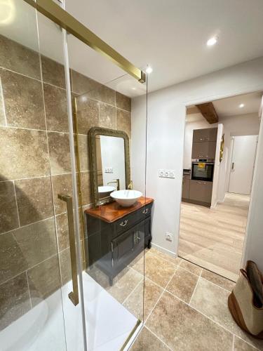 une salle de bain avec un lavabo et un miroir dans l'établissement La Nichée appartement 2 chambres, à Trévoux