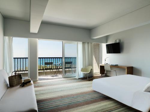 a hotel room with a bed and a view of the ocean at Doryssa Seaside Resort in Pythagoreio