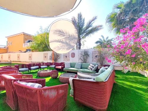 a group of wicker chairs and tables on a lawn at Royal private pool, Lux 7-bedroom villa on Marina in Dubai
