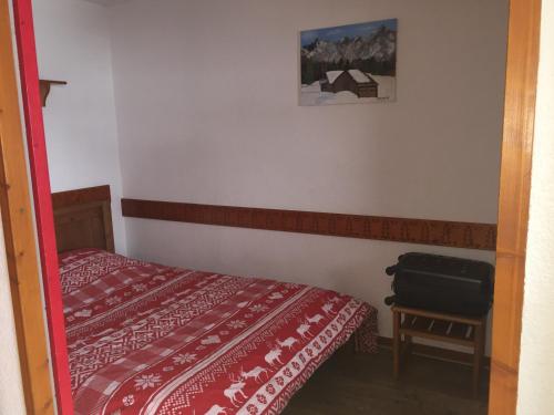- une petite chambre avec un lit et une valise dans l'établissement LE CHRISTIANIA Les bergers, à L'Alpe-d'Huez