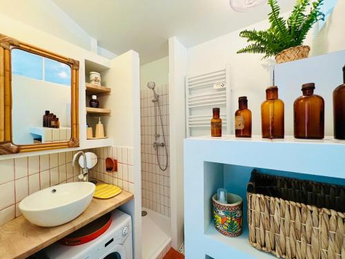 une salle de bain avec un lavabo et un miroir dans l'établissement 2 pièces, cocon de charme, les pieds dans l'eau !, à La Grande Motte