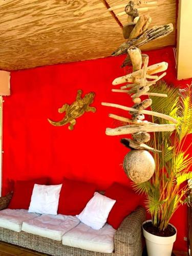 a room with a red wall with a couch and a red wall at Villa Coco Caraïbes in Deshaies