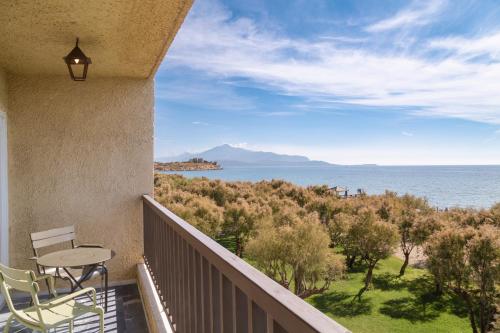 a balcony with a table and chairs and the ocean at Doryssa Seaside Resort in Pythagoreio