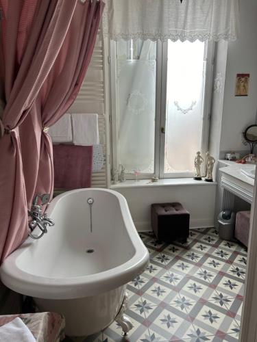 a bathroom with a tub and a sink and a window at Le Château de Failloux, Piscine intérieure in Épinal