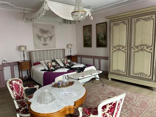 a living room with a bed and a table and chairs at Le Château de Failloux, Piscine intérieure in Épinal