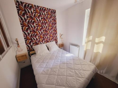 - une chambre dotée d'un lit avec un mur à motifs dans l'établissement Cali, appartement intramuros, à Avignon