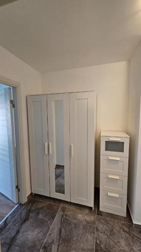 a white cabinet and a dresser in a room at Airport Residence in Otopeni