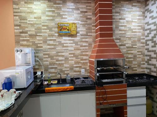 a kitchen with a counter top with a stove at Casa Maria Alice in Manhã