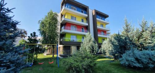 a tall apartment building with red and yellow windows at Airport Residence in Otopeni