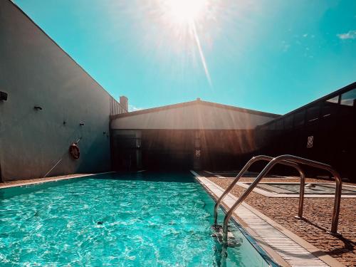 a swimming pool with blue water in a building at Lawendowe Termy in Uniejow