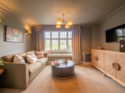 a living room with a couch and a table at Mill End Hotel in Chagford