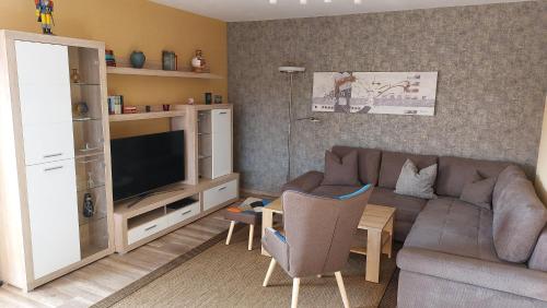 un salon avec un canapé et une télévision dans l'établissement Ferienwohnung Sonja Sinsheim, à Sinsheim