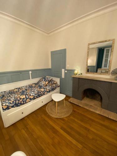 - une chambre avec un lit, une cheminée et un miroir dans l'établissement L'Imprimerie A1, studio cosy au cœur de la Roche !, à La Roche-sur-Yon