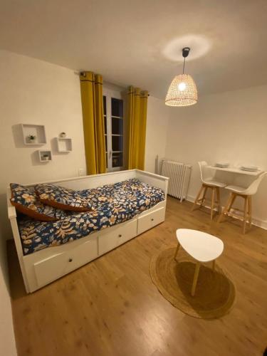 une chambre avec un lit, une table et une chaise dans l'établissement L'Imprimerie B3, studio cosy au coeur de La Roche, à La Roche-sur-Yon
