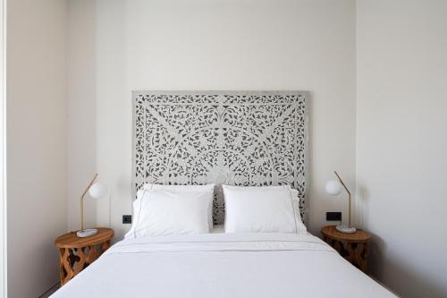 a bedroom with a white bed with two lamps at Artemis Apollonas Villa I Luxury Escape with Pool in Káïna