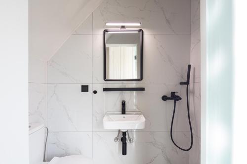 a white bathroom with a sink and a mirror at Artemis Apollonas Villa I Luxury Escape with Pool in Káïna