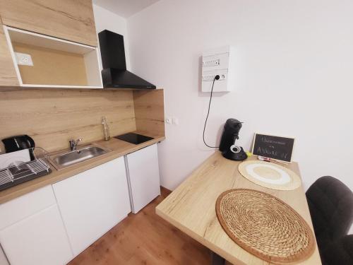 une petite cuisine avec une table en bois et un évier dans l'établissement Leni, appartement intramuros, à Avignon