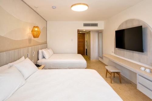 a hotel room with two beds and a flat screen tv at Viva Miches by Wyndham, a Trademark All Inclusive Resort in Miches