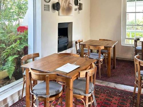 two tables and chairs in a room with a fireplace at Temenos Retreat in McGregor