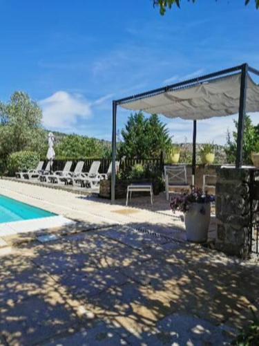 - un pavillon avec une table et des chaises à côté de la piscine dans l'établissement Le CLOS MARFRUMA, à Montréal