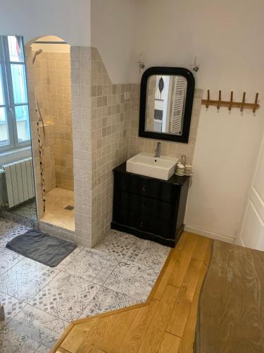 Un baño con lavabo y ducha con espejo. en restaurant Dame L'Oie, en Pernes-les-Fontaines