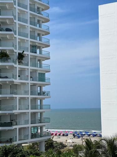 a tall apartment building next to a beach at Apartment with direct access to the Sea in CTG in Cartagena de Indias