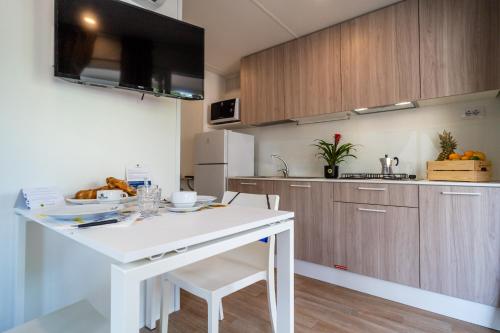 a kitchen with a white island in a room at Club del Sole Viareggio Family Collection in Torre del Lago Puccini